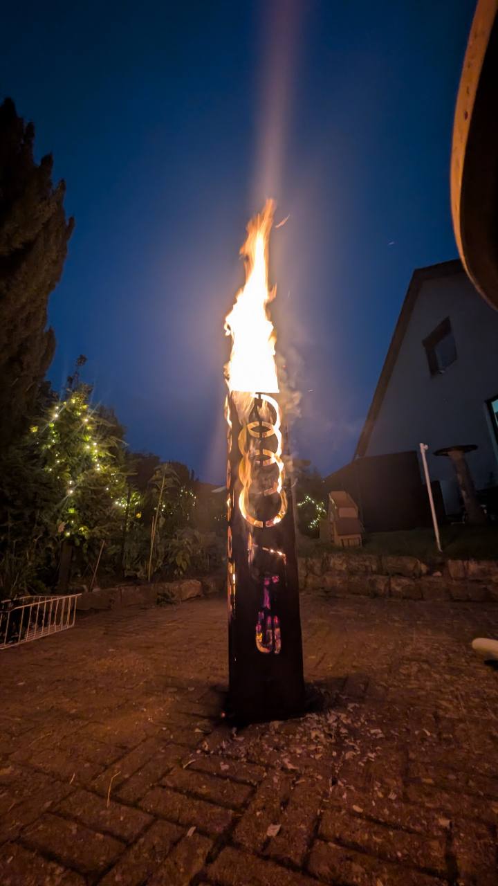 Hohe Feuertonne mit Audi Logo und Schriftzug in Betrieb
